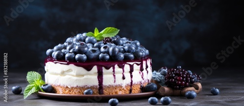 Delicious fresh blueberry or blackcurrant cake with cream cheese on a dark concrete background. Creative banner. Copyspace image