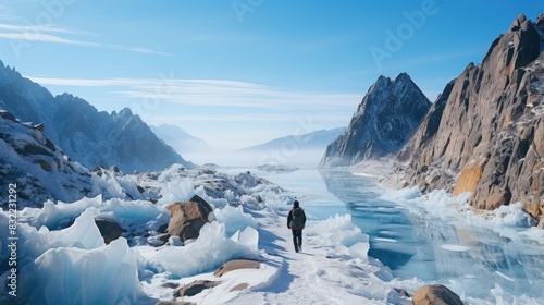 An adventurer hikes through a stunning frozen landscape with ice formations and sheer mountain peaks