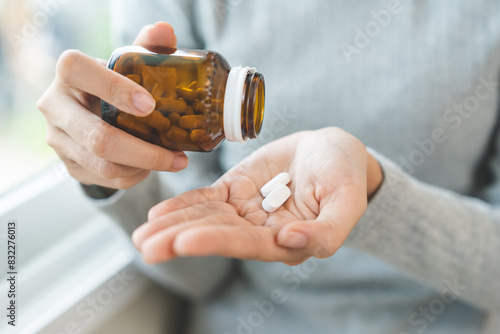 Sick ill asian young woman, girl hold tablet pill on hand pour capsule from medication bottle, painkiller medicine from stomach pain, head ache, pain for treatment, take drug or vitamin, health care.