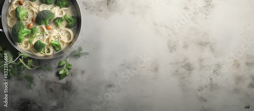 Pasta with green vegetables and creamy sauce in copper saucepan Grey stone background Top view. copy space available