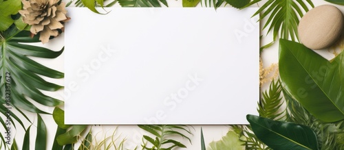 A beautifully arranged summer themed mockup featuring a blank greeting and invitation card surrounded by dried tropical leaves offering ample copy space for customization