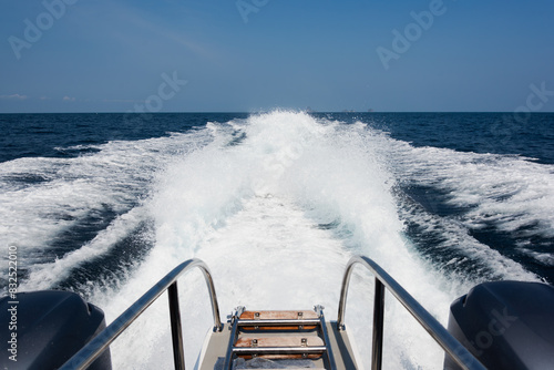 A four-engine speedboat moving at full speed. Traces on the water from powerful speed boat engines 
