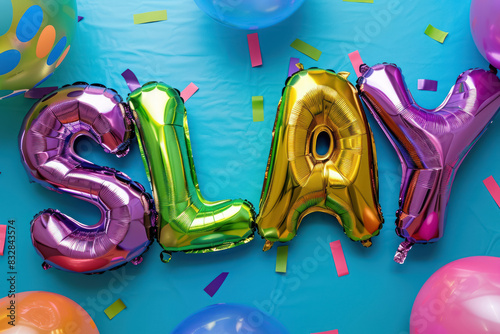 colorful foil balloons spelling 'slay' against a bright backdrop