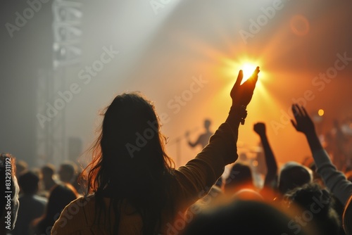 A person raises their hand at a concert capturing a moment of connection with the music and crowd