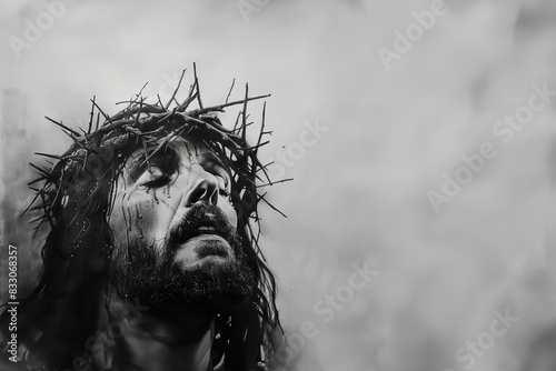 Portrait de Jésus Christ au crayon noir ou carbone et fusain, avec sa couronne d'épines la tête tournée vers le ciel les yeux fermés, sur un fond gris texturé, copyspace espace négatif