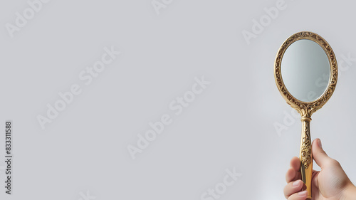 Beauty Reflection: Hand Mirror on Light Grey Background