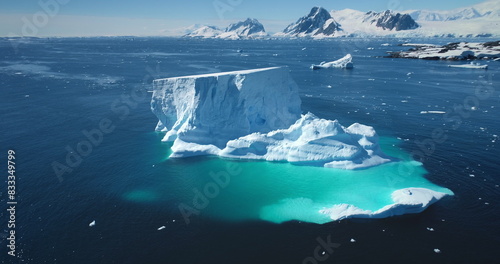 Antarctica melting iceberg float blue water polar ocean. Arctic Ice natural beauty of towering glacier, blue sunny sky. Ecology, melting ice, climate change, global warming. Aerial drone panorama