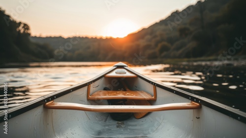 Photo of a canoe on a calm lake during sunset, with the view focused on the bow of the canoe and a serene landscape in the background.
