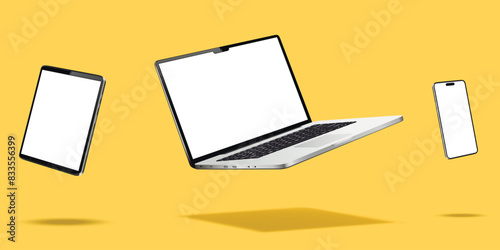 Laptop computer, smartphone and tablet while levitating in the air on a yellow background