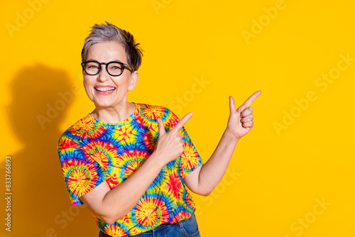 Photo of glad lovely nice woman wear trendy print clothes demonstrate empty space isolated on yellow color background