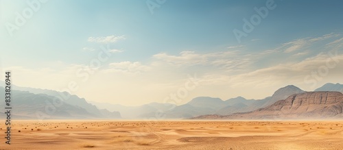 A scenic bare mountain range and sandy valley desert in the Middle East or Africa make a captivating landscape for photography with ample copy space image in a horizontal frame.