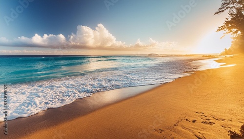 wide view of the sunrise in boucan canot beach in the summertime with blue sea water and yellow sand in reunion