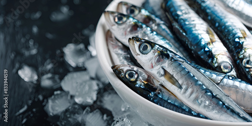 a plate of fish with eyes wide open in a close-up shot The fish appear to be fresh and possibly a type of sardine or anchovy,