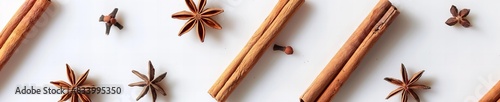 Cinnamon sticks and anise stars on white surface 
