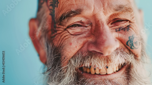 Close up portrait of happy elderly optimist man with tattoo face. Modern Aging.