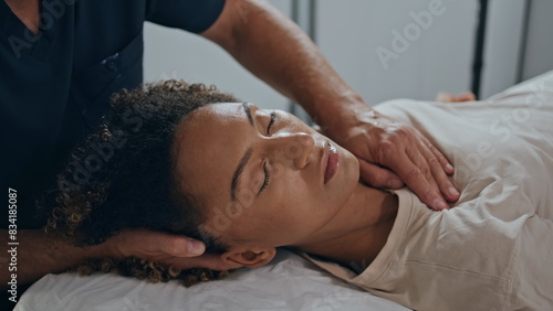 Closeup osteopath hands healing patient trauma. Relaxed woman lying on session