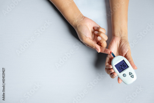 Woman's hands checking diabetes and hyperglycemia with digital blood sugar meter. Healthcare and medical concept 