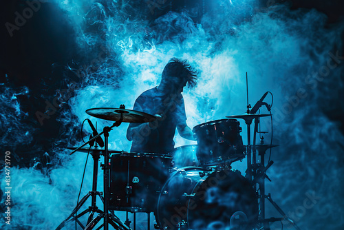 The drummer sits behind a drum kit in the smoke and spotlight. Generative AI