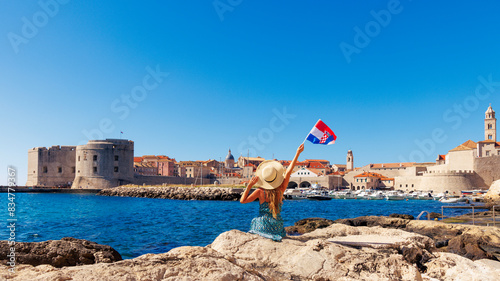 Happy female holding croat flag, enjoying panoramic view of Dubrovnik city landscape- Croatia