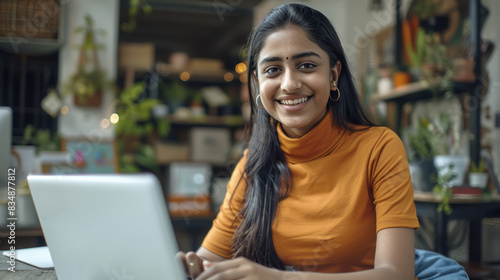 young happy indian woman using laptop at home