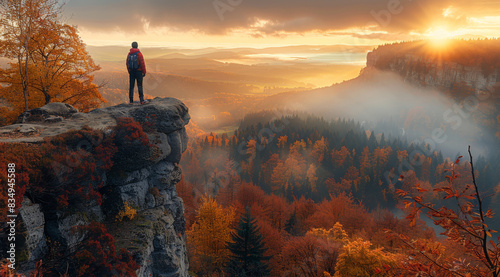 A photographer on top of the mountain, capturing breathtaking autumn landscape with forest and mountains in countryside at sunrise. Hiker man standing on cliff. Generative AI.