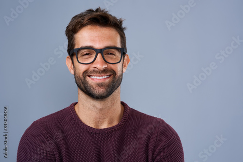 Studio, glasses and man with portrait, proud and wellness with eye care, product and lens for vision. Blue background, face and happiness for person, prescription and eyewear with fashion in USA