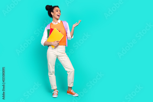 Full size photo of nice young girl book empty space ad wear vest isolated on teal color background