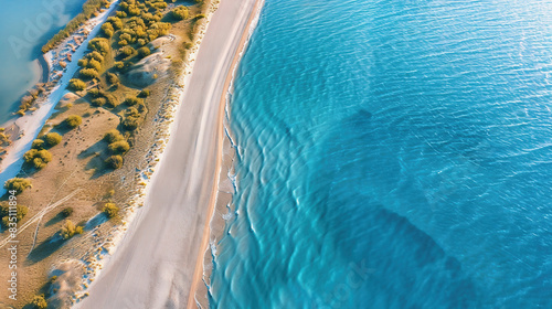 Top-down aerial view of a clean white sandy beach on the shores of a beautiful sea.