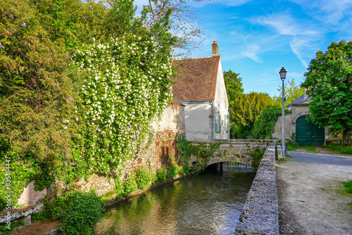 River La Cléry flowing at the foot of the houses of Ferrière-en-Gâtinais in the French department of Loiret, Centre Val de Loire, France