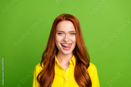 Photo portrait of pretty young girl lick teeth yummy wear trendy yellow outfit isolated on green color background
