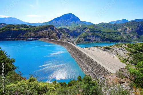 Aerial view of the Dam of Serre-Ponçon, an embankment dam made of compacted soil built on the Durance river in the French Alps