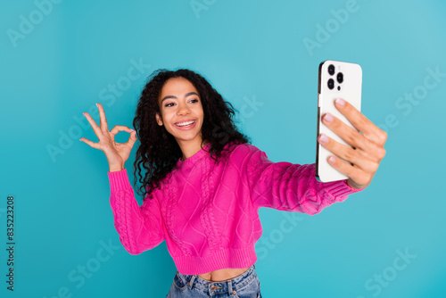 Photo portrait of attractive teen girl selfie photo okey dressed stylish pink clothes isolated on aquamarine color background