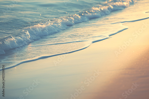 Gentle waves lapping a sunset beach with warm golden light