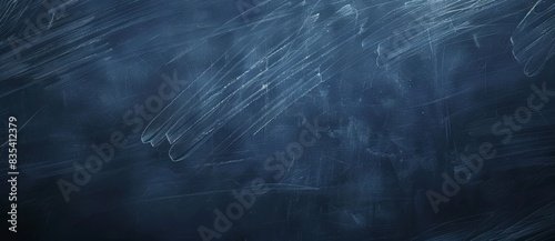 It is a copyspace image of a dark blue chalkboard with traces of erasing creating a textured background
