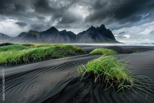 Icelandic black sand beach with vestrahorn mountain in the background, cloudy sky, grassy dunes, dramatic lighting, professional photography