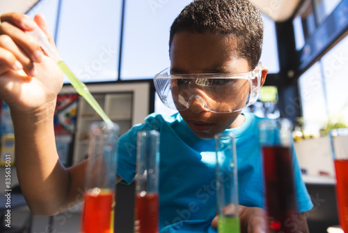 Biracial boy explores science experiment at school in the classroom