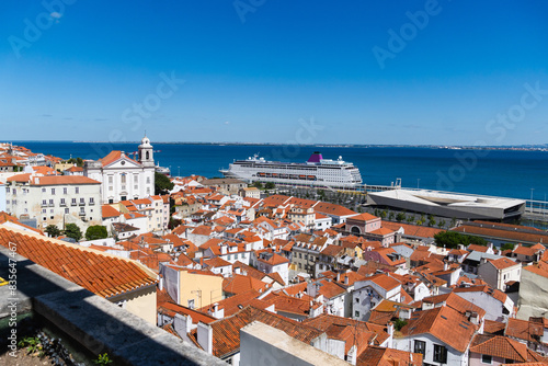 View of the beautiful skyline of Lisbon, Portugal, with red roofed, colorful houses in the Alfama district during a sunny day