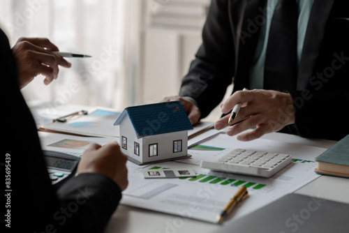 accommodation agency and client are planning together about finance because the client wanted to buy a house, meeting in property office with expert of how to find the best house for rent