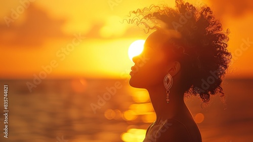  A woman facing sunset, head turned sideways Hair billows with wind Sun sets in background