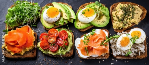 Avocado sandwiches with salmon, eggs, basil, and micro greens served on a white plate with a cup of coffee; perfect for a copy space image.