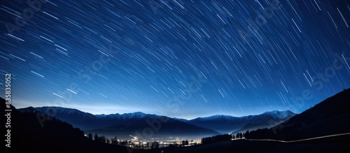 Human silhouette watches star trails circling Polaris in the north with a copy space image.