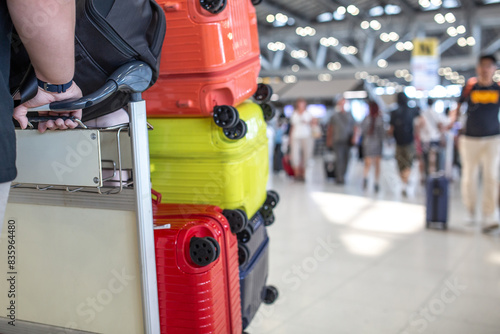 A view of a man pushing a trolley with four suitcases on it.