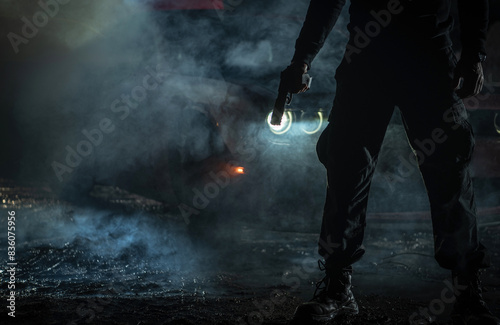 Silhouette of a Person Holding a Flashlight in Smoky Nighttime Setting