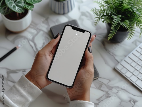 A close-up of a person using a smartphone to create a targeted ad campaign on a minimalist desk. The clean surroundings highlight the simplicity and effectiveness of mobile advertising.