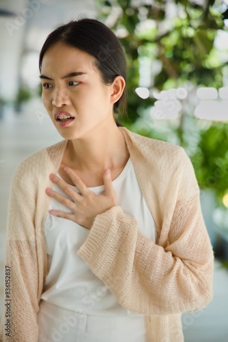 ill Asian woman with acid reflux or gerd symptoms, acidic esophageal, heartburn sickness