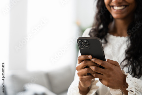 Black woman's hands using phone with white copy space. Positive Indian person surfing social media.