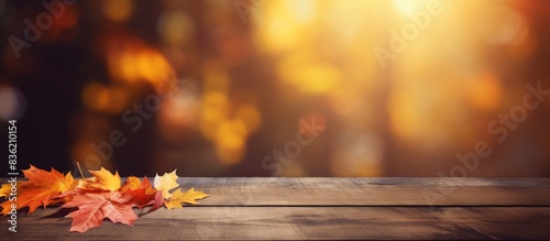 Autumn-themed background complements a wooden table with a clear surface for a vibrant copy space image.