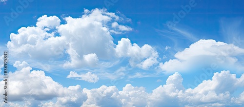 Daytime blue sky with fluffy white clouds, perfect as a background with copy space image.