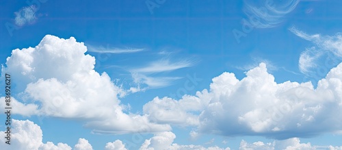 Background with white clouds against a blue sky, providing copy space image.