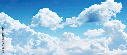 Blue sky with fluffy clouds creating a serene atmosphere with ample copy space image.